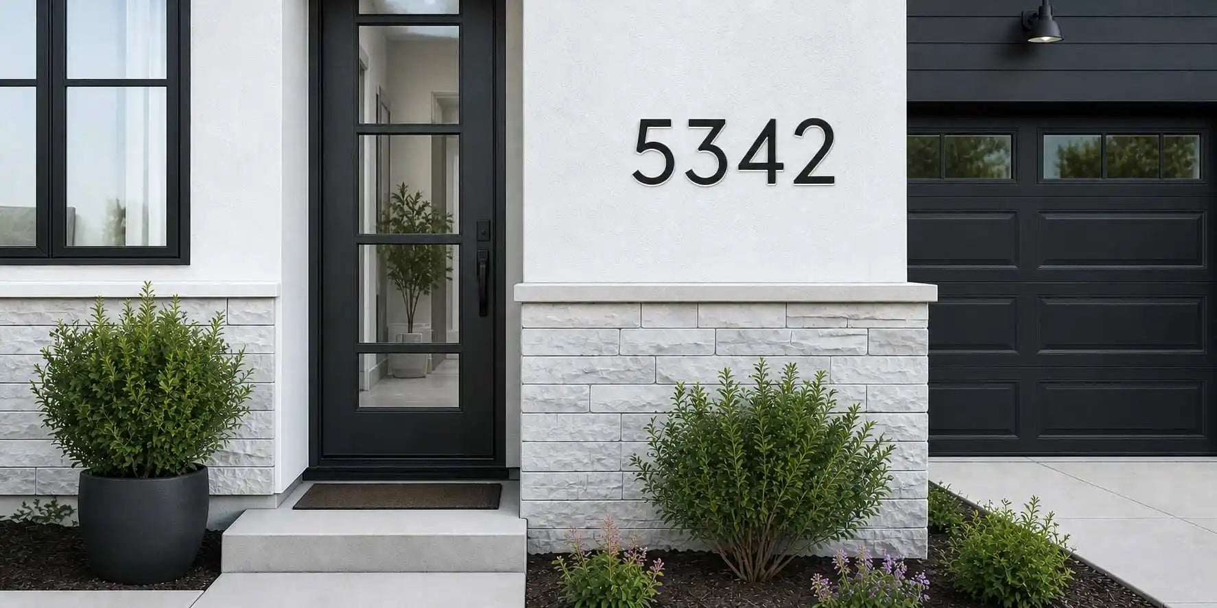 Custom solar LED house number 5342 installed on a modern white exterior wall during the day